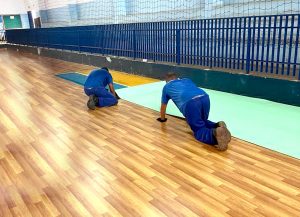 Funcionários colocando o novo piso no Ginásio de Esportes